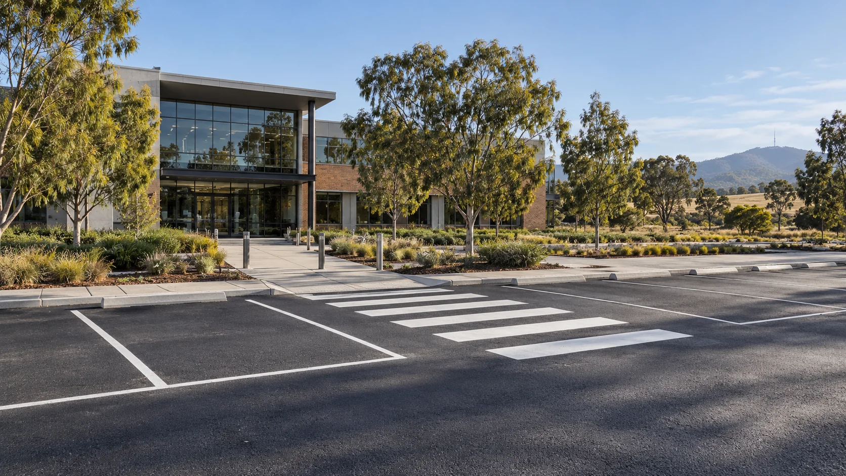 Illustrative landscaped office campus with organised parking bays and a pedestrian crossing